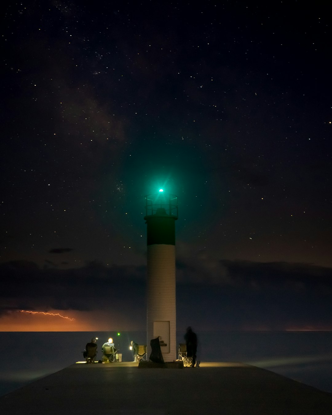 people standing near light tower during night time