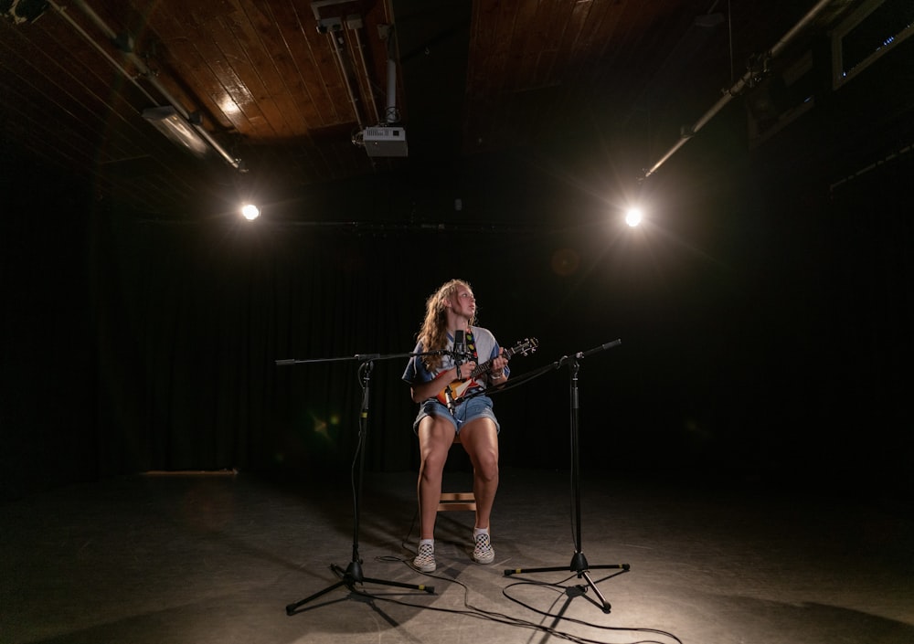 woman in blue denim shorts singing on stage