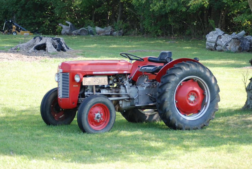 red tractor on green grass field during daytime