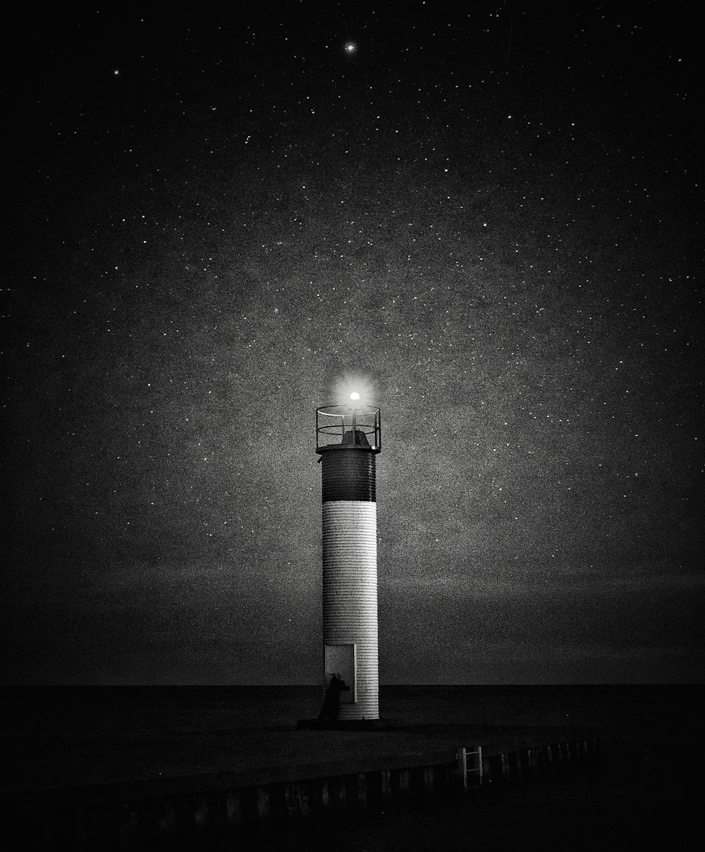 grayscale photo of lighthouse during night time