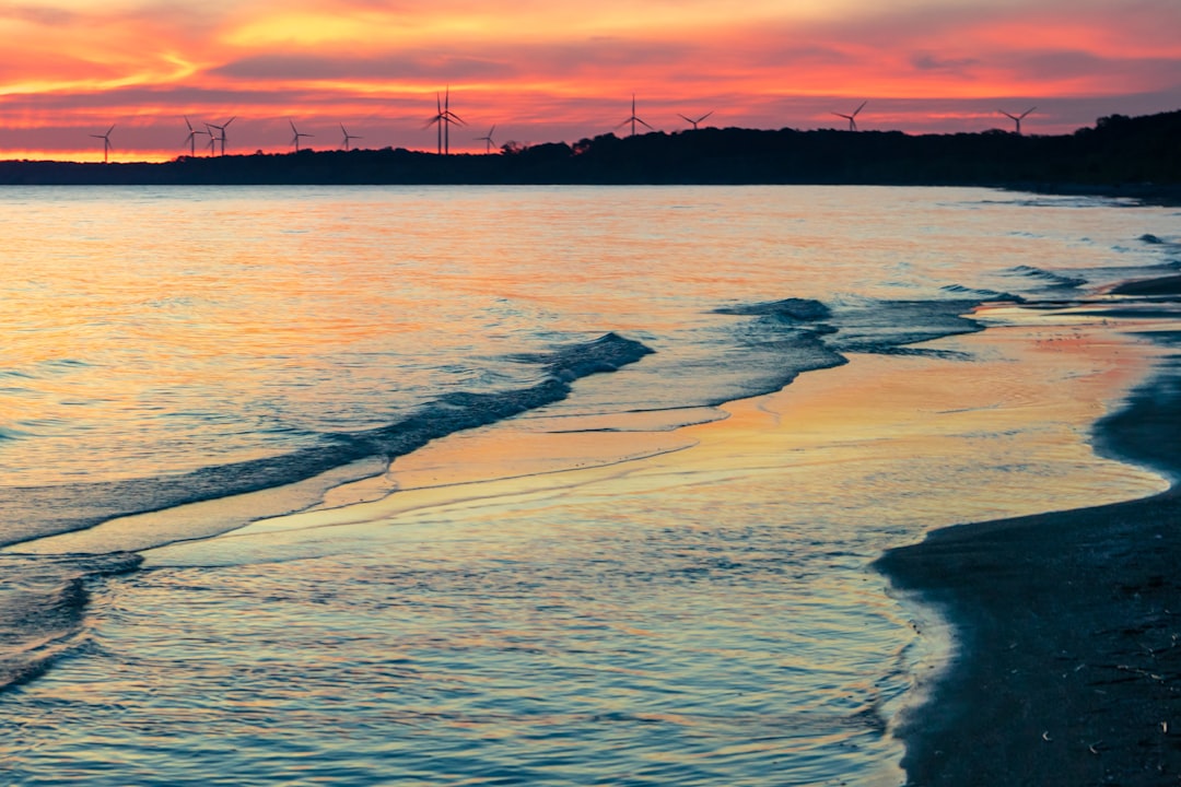 sea waves crashing on shore during sunset