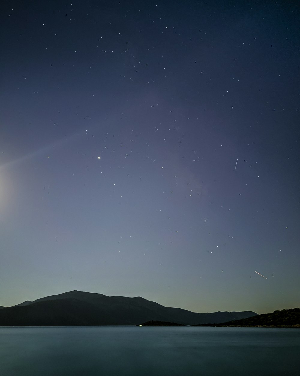 silhouette of mountain under starry night