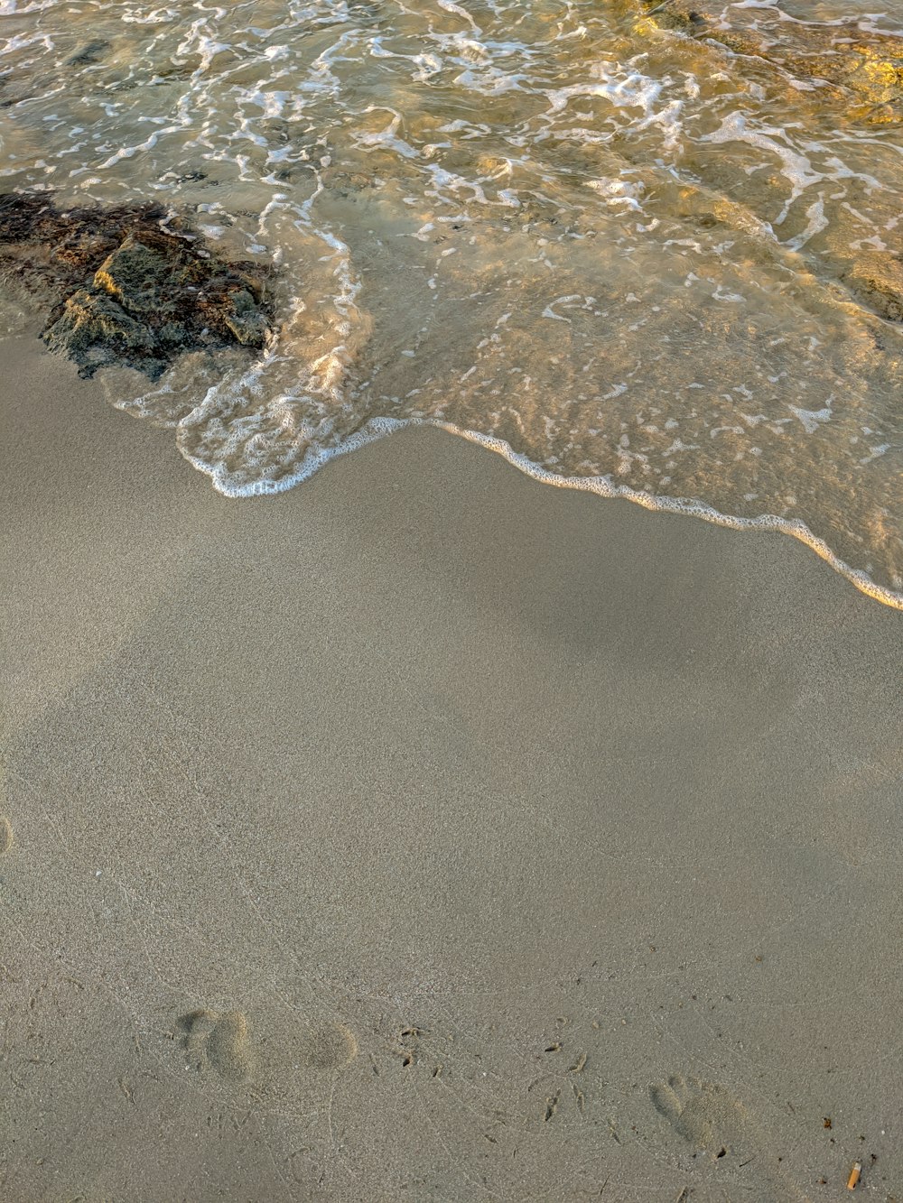 sable brun avec des vagues d’eau