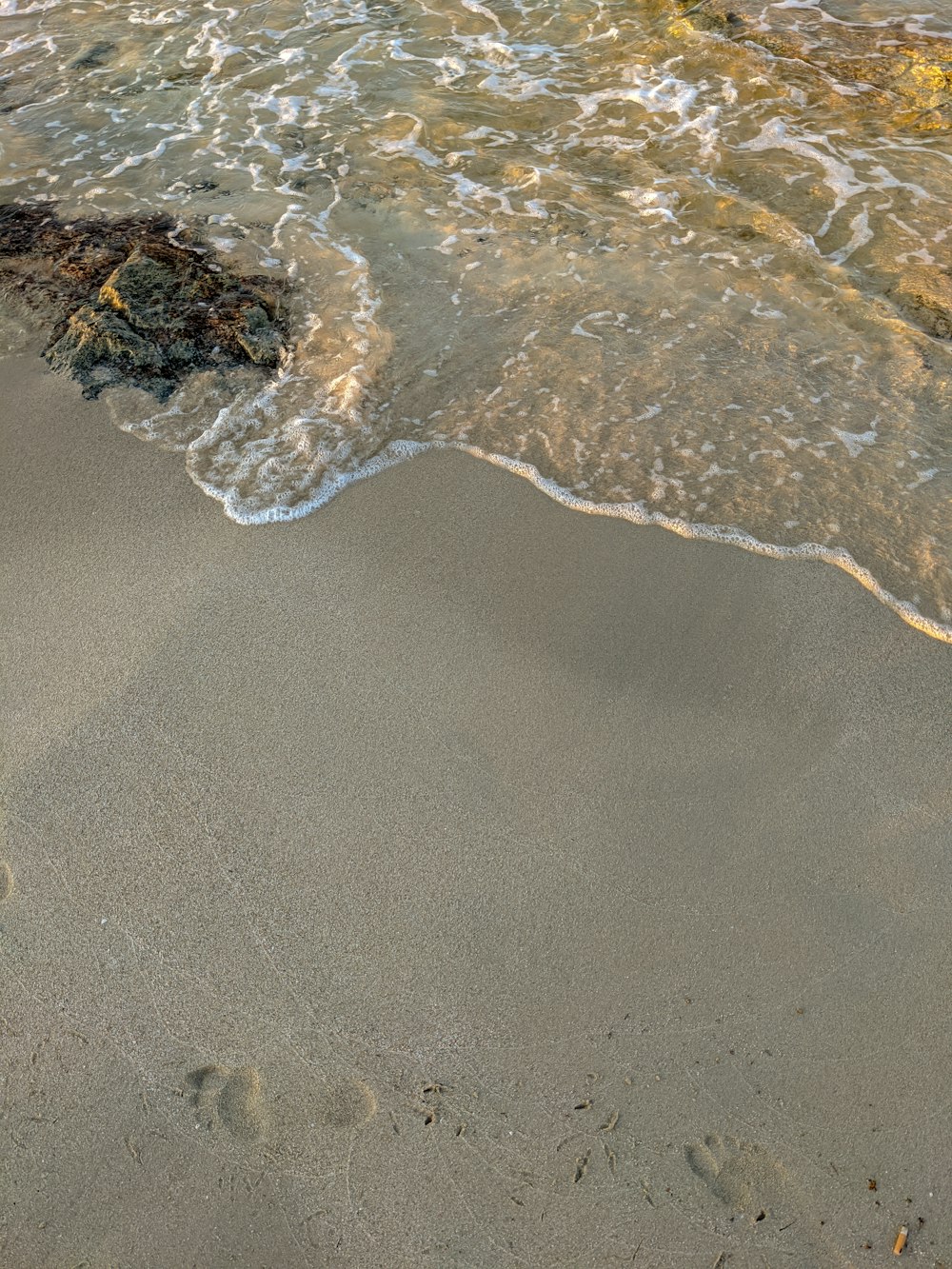 brown sand with water waves