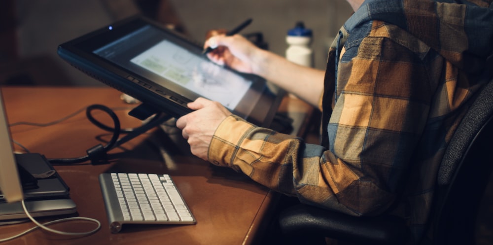 person in brown and black plaid long sleeve shirt using black laptop computer
