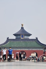 people standing near green and brown building during daytime