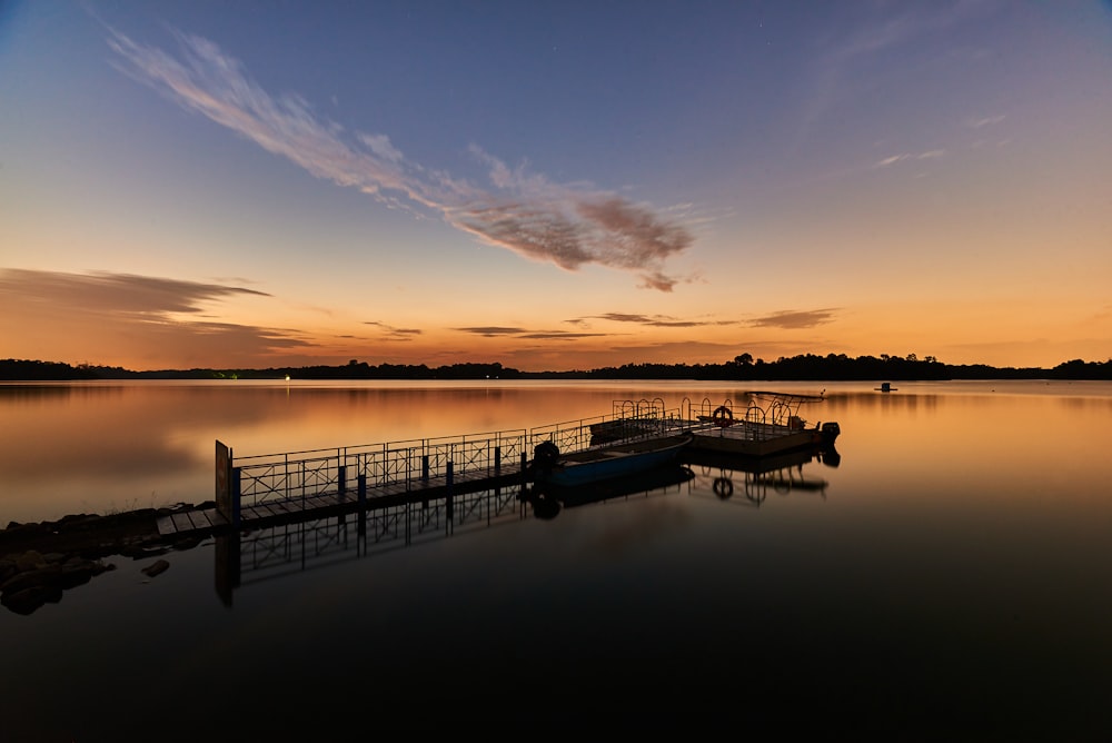 silhouette of boat on sea during sunset