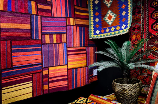 A vibrant bohemian-style room with a colorful hand-knotted rug full of lively patterns.