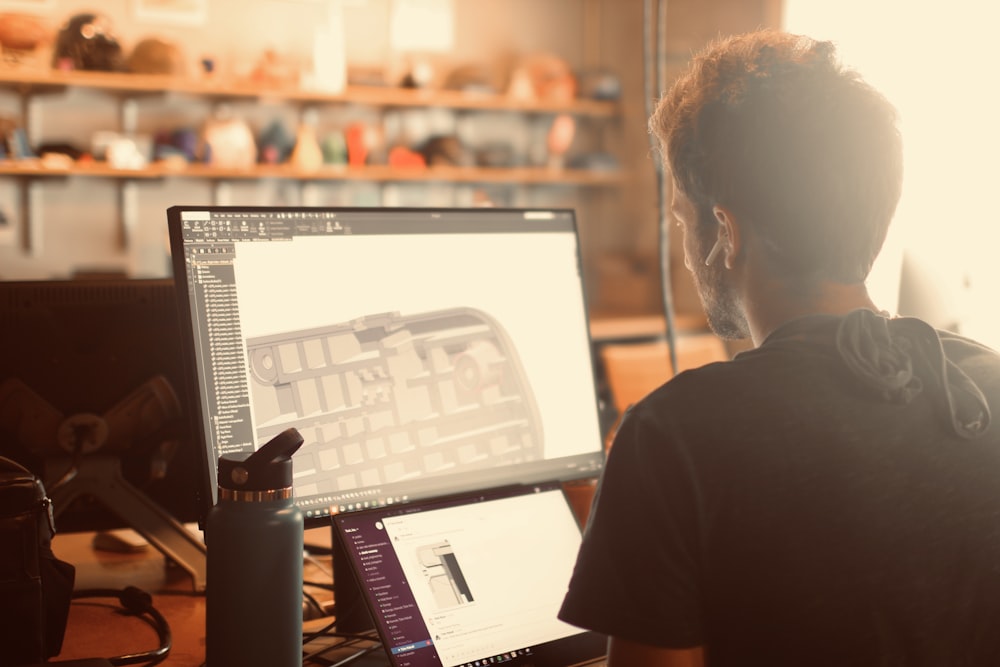 man in black shirt using macbook pro