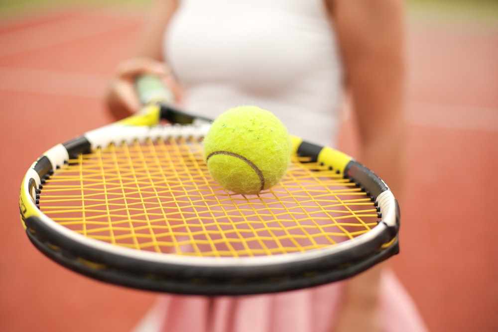 Pelota de tenis verde sobre textil blanco