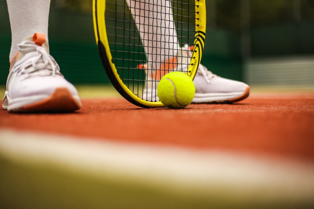 Person in weißen Nike-Turnschuhen beim Tennis