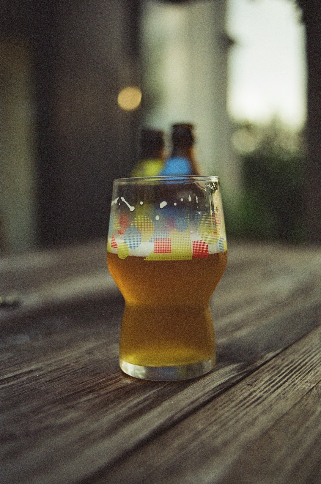 clear drinking glass with brown liquid on brown wooden table