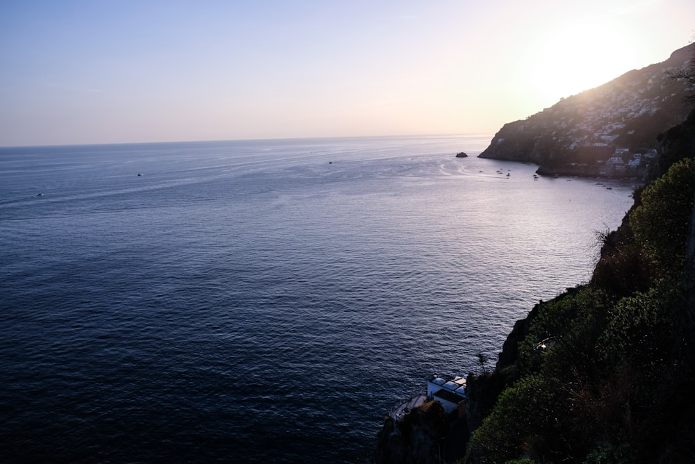 body of water near mountain during daytime