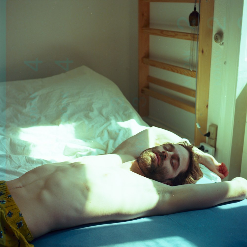 topless man lying on bed