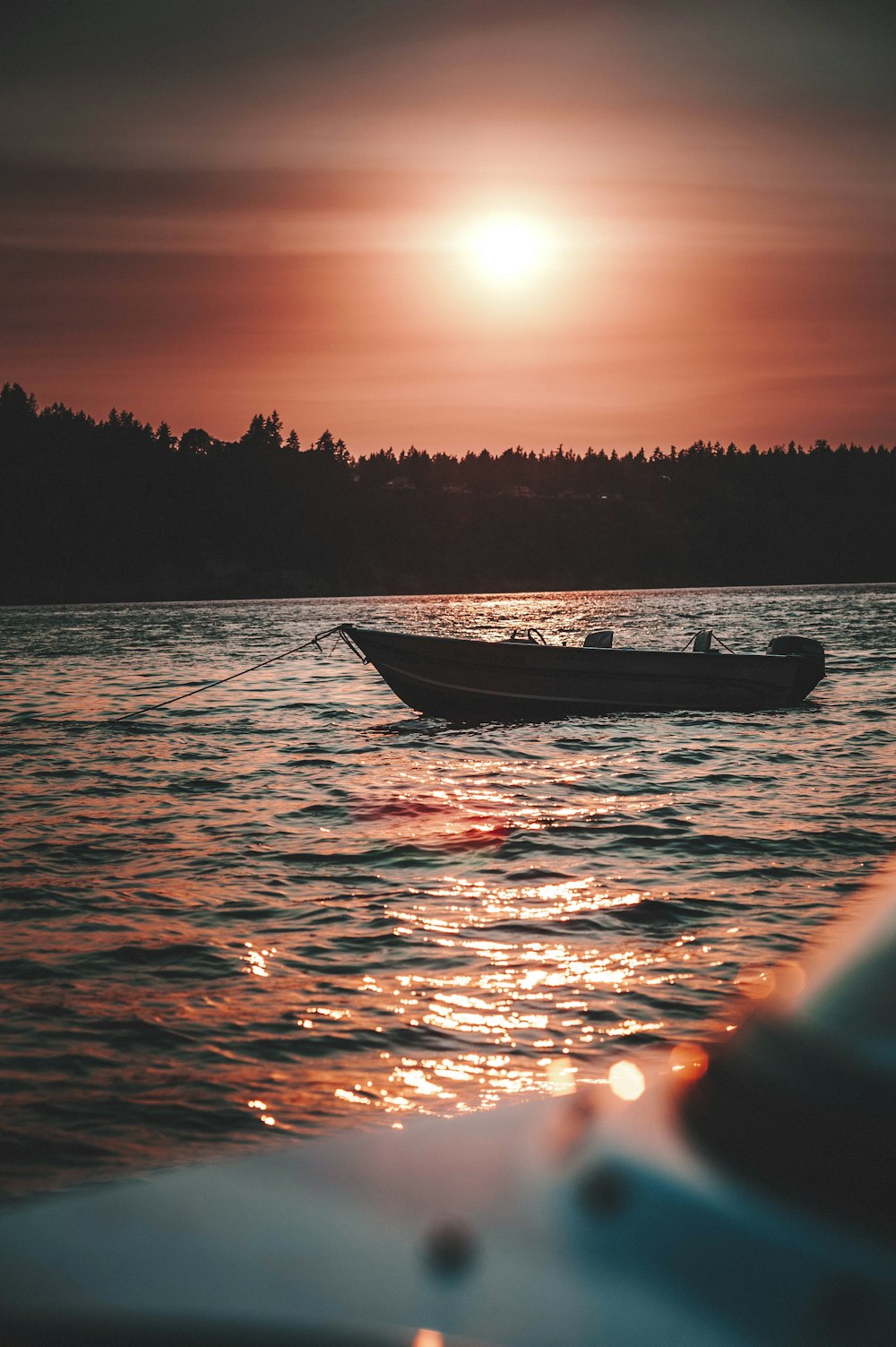 silhouette of person riding on boat during sunset