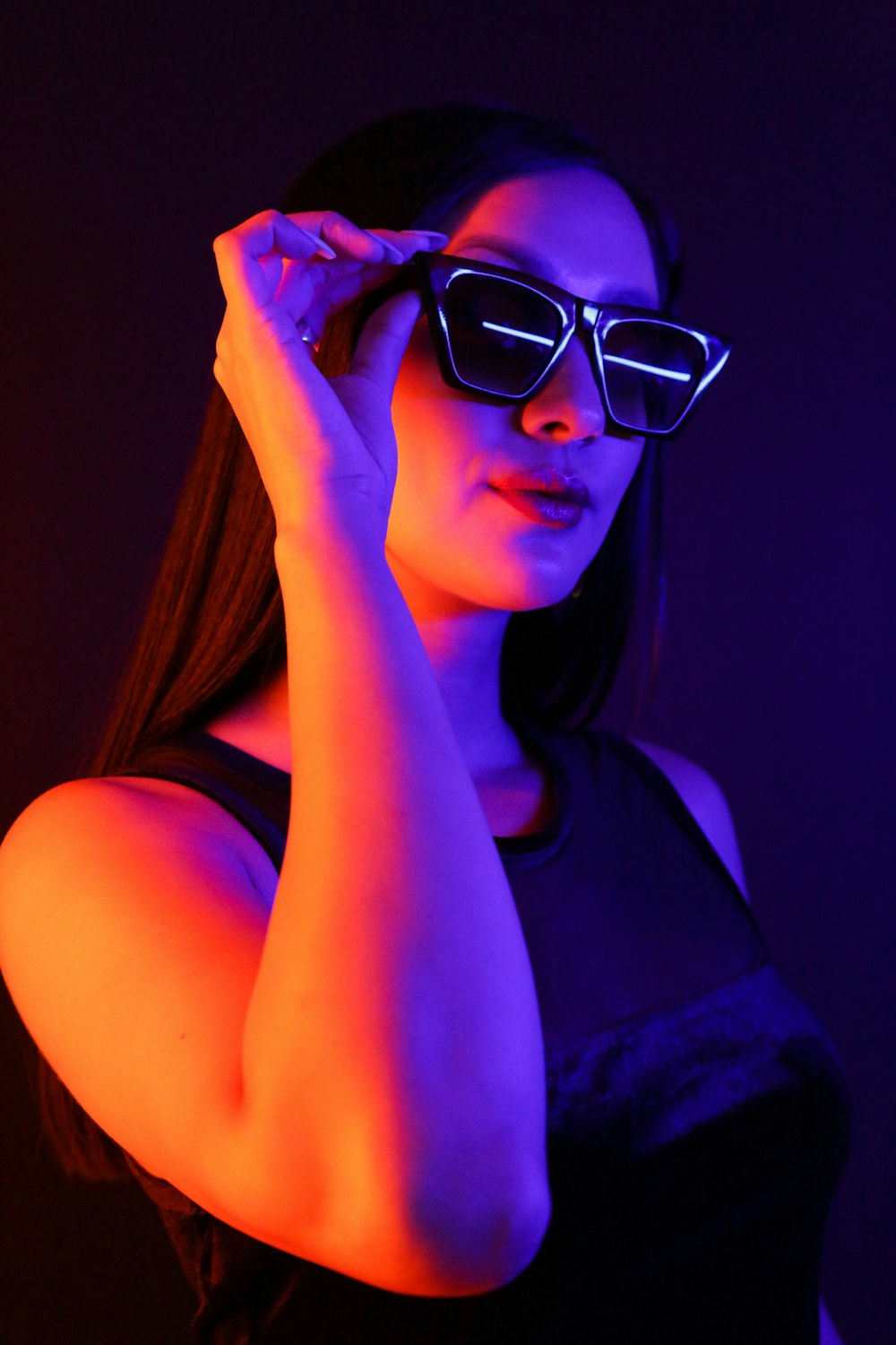 Frau in schwarzem Tanktop mit schwarz gerahmter Sonnenbrille