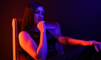woman in black tank top sitting on black chair