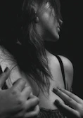 Intimate black-and-white portrait of a woman in flowing fabric, showcasing delicate shadows and highlights.