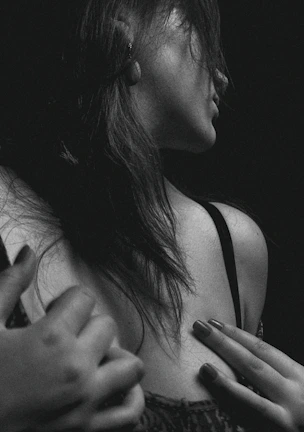 Intimate black-and-white portrait of a woman in flowing fabric, showcasing delicate shadows and highlights.