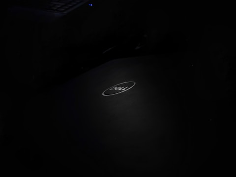 A dark image with a Dell laptop logo centrally placed, featuring a softly illuminated keyboard in the top left corner.