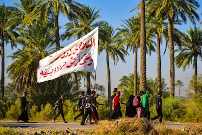 people holding flags standing on brown field during daytime iraq teams background