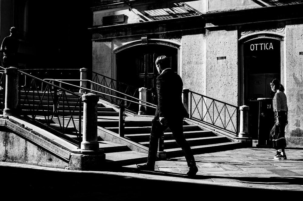 man in black suit walking on staircase