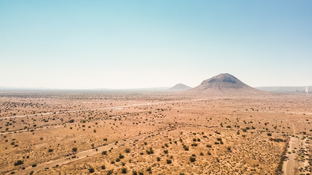 brown sand field near mountain during daytime