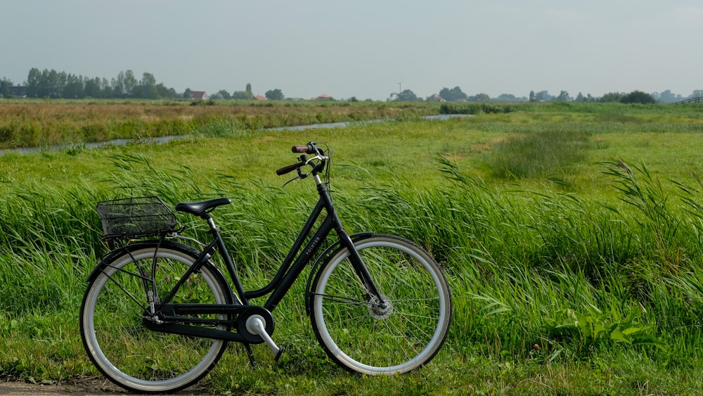 black commuter bike on green grass field during daytime