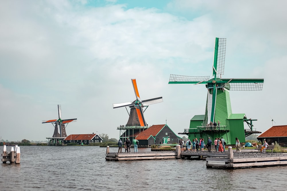 green windmill near body of water during daytime