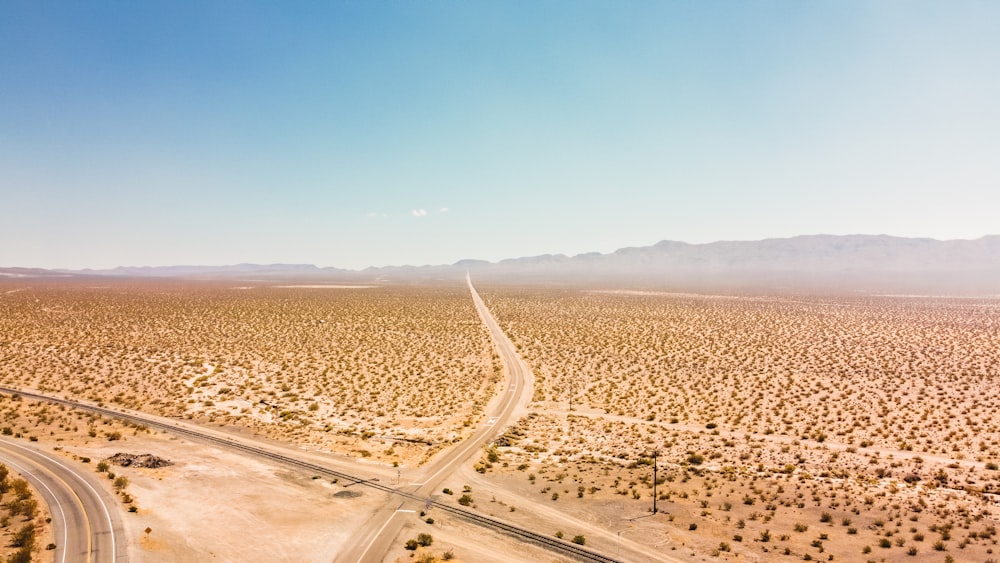 brown sand field under blue sky during daytime