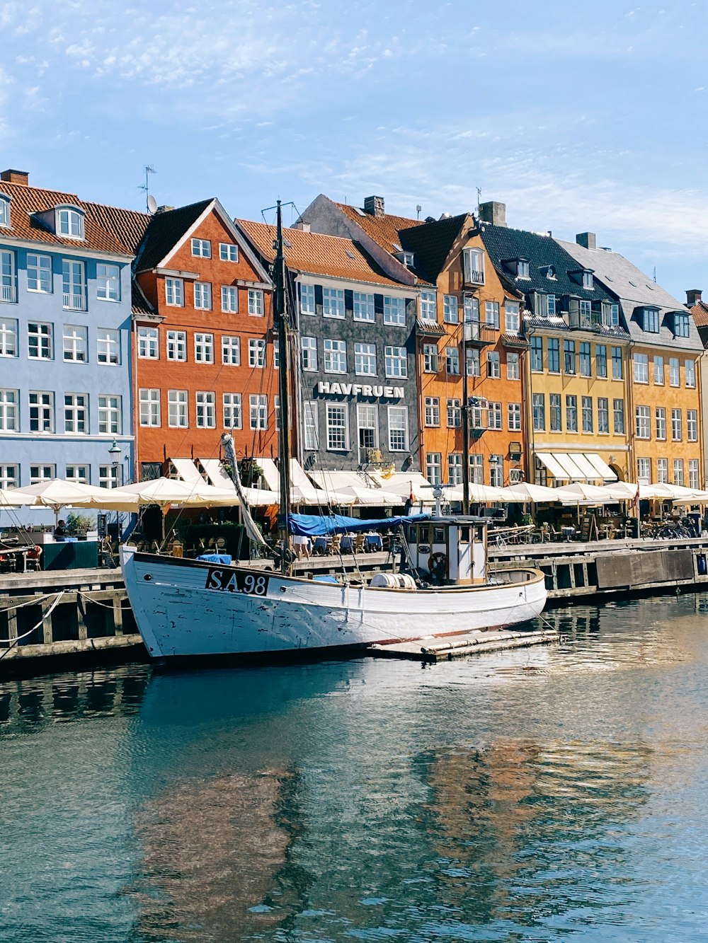 white boat on body of water near buildings during daytime