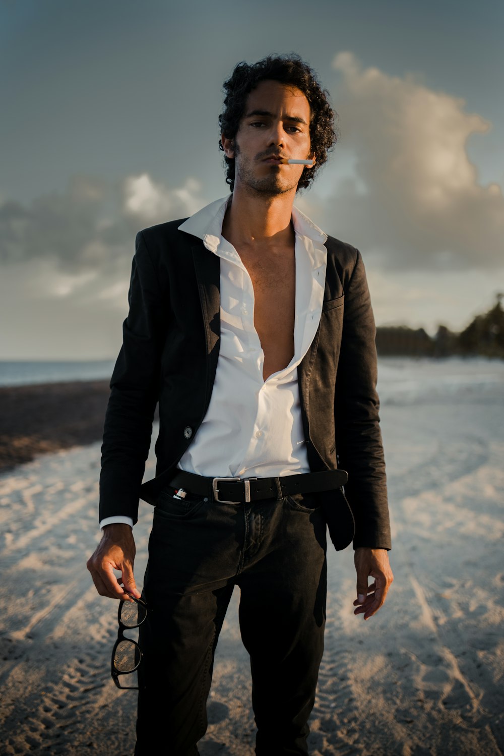 woman in black blazer standing on seashore during daytime