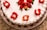 A close-up of a beautifully decorated chocolate cake with fresh strawberries on top.