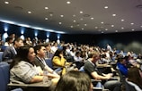 An audience attentively listening to a speaker at a seminar.