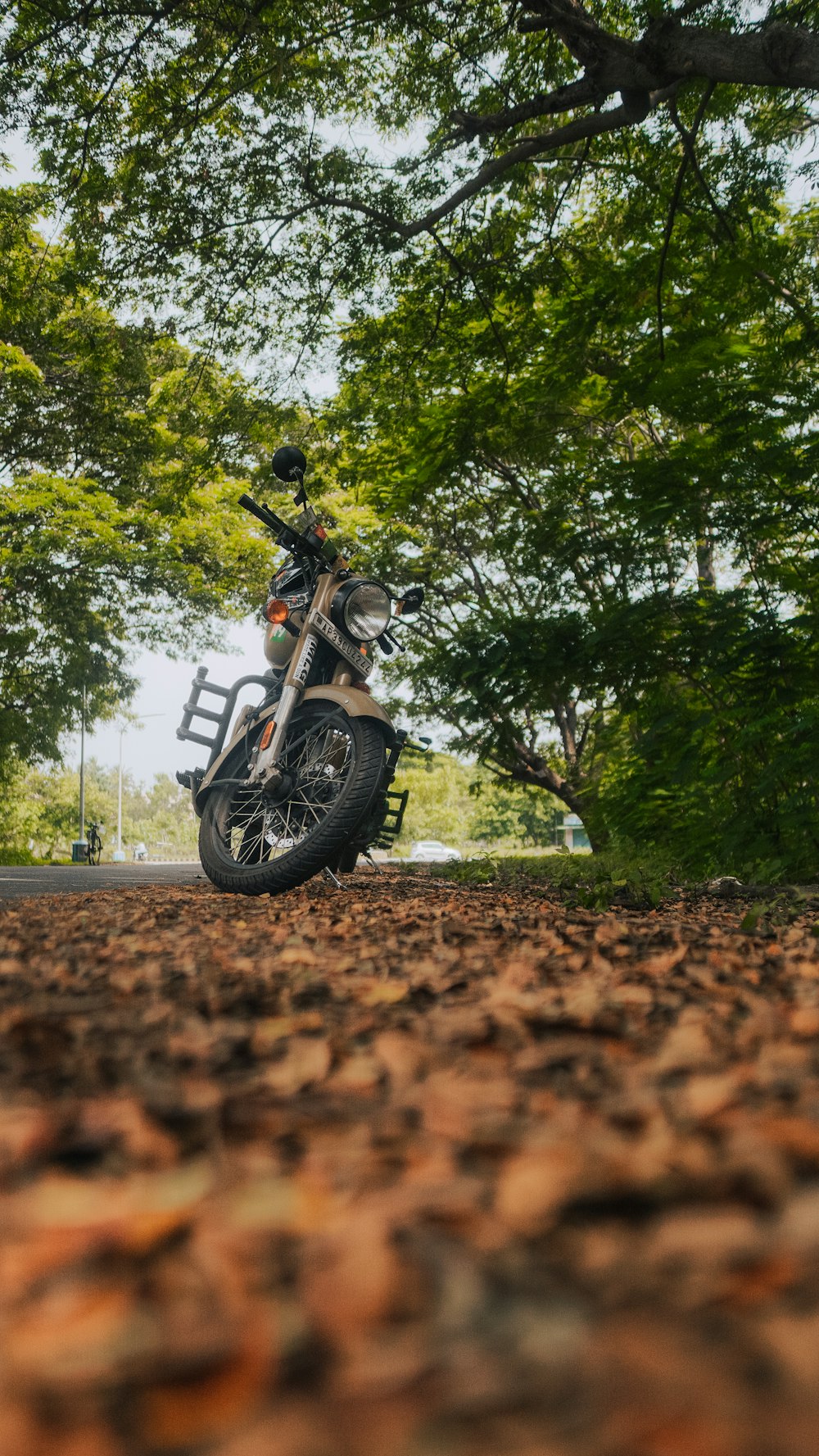 Motocicletta nera e rossa parcheggiata su una strada sterrata marrone durante il giorno