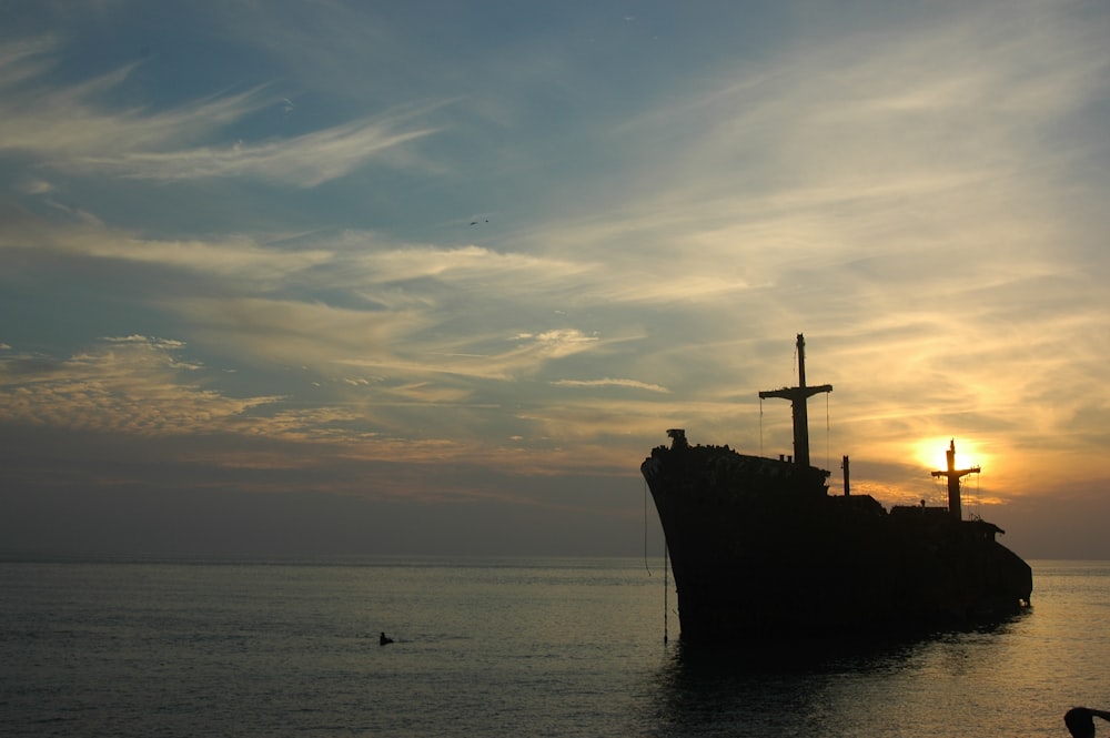 brown ship on sea under white clouds and blue sky during daytime