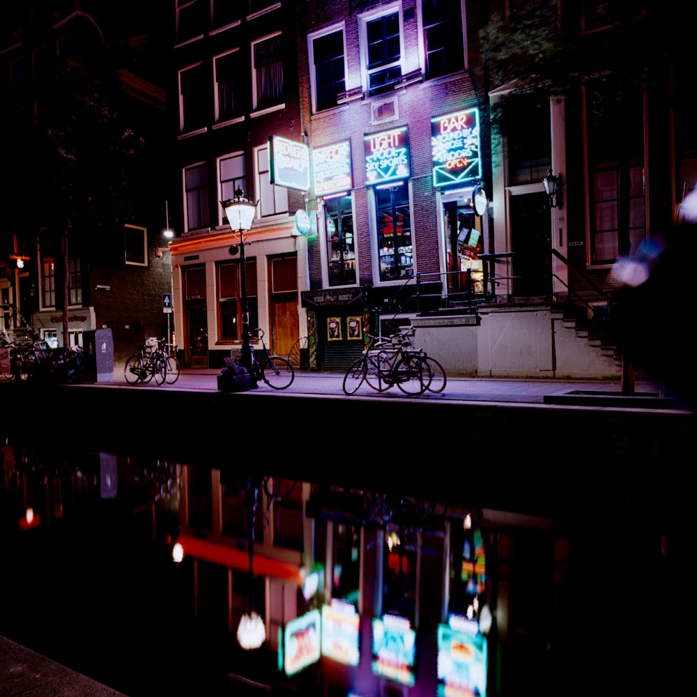 black bicycle parked beside building during night time