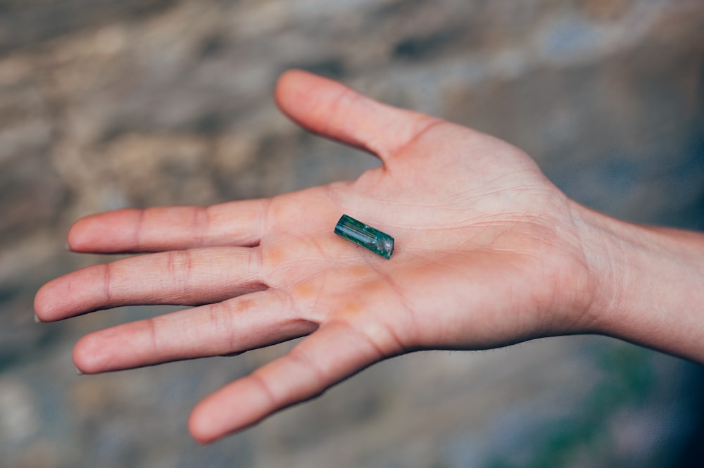 green medicine pill on persons palm