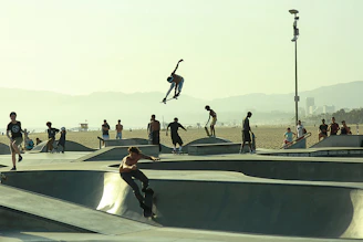 A vibrant skate park scene with diverse skaters enjoying various styles of skating under a clear blue sky.