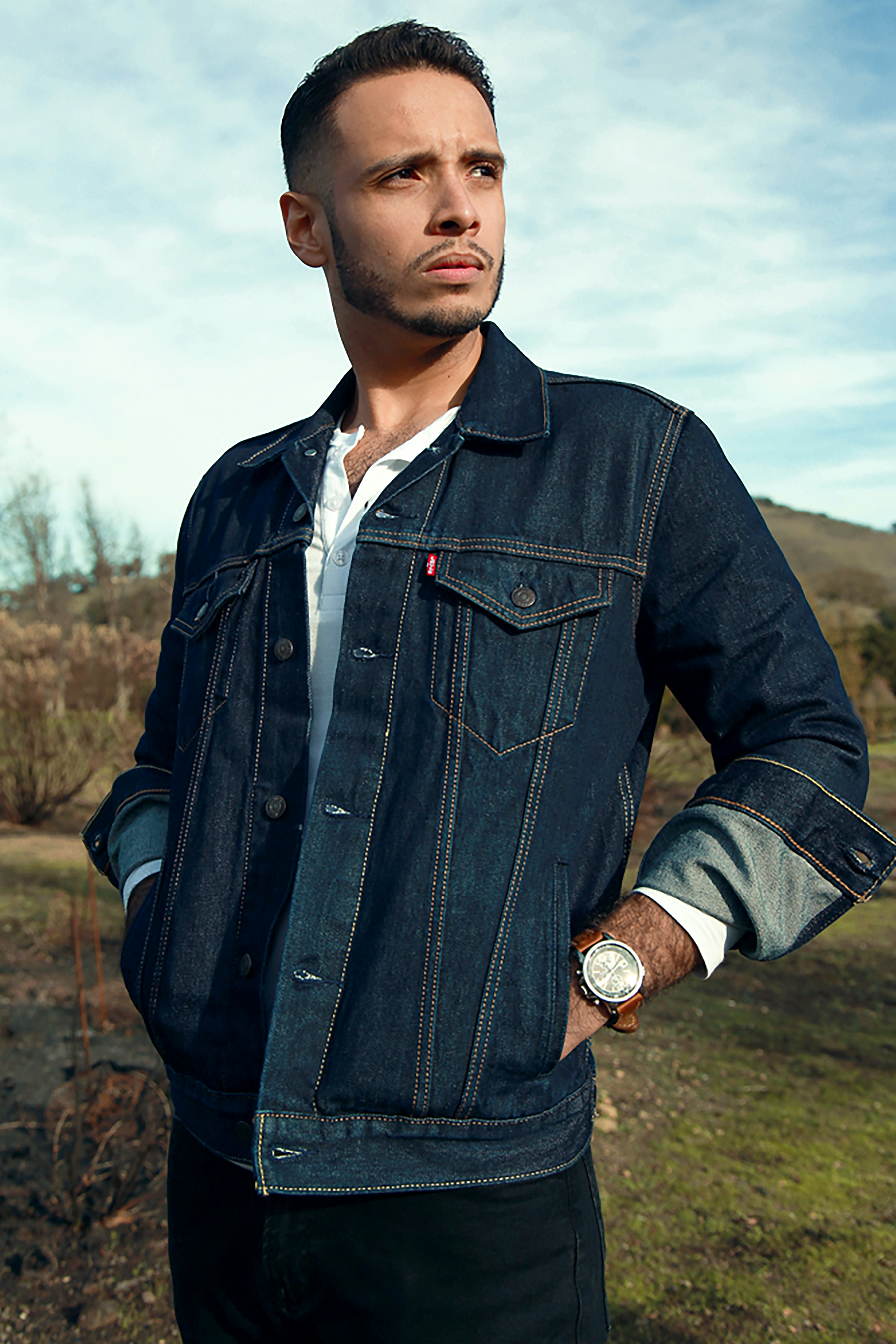 man in black button up jacket wearing black round analog watch