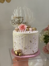 A beautifully decorated pink-themed eggless birthday cake with fresh cream and delicate floral accents.