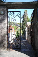A charming garden gate partially open, inviting visitors inside.