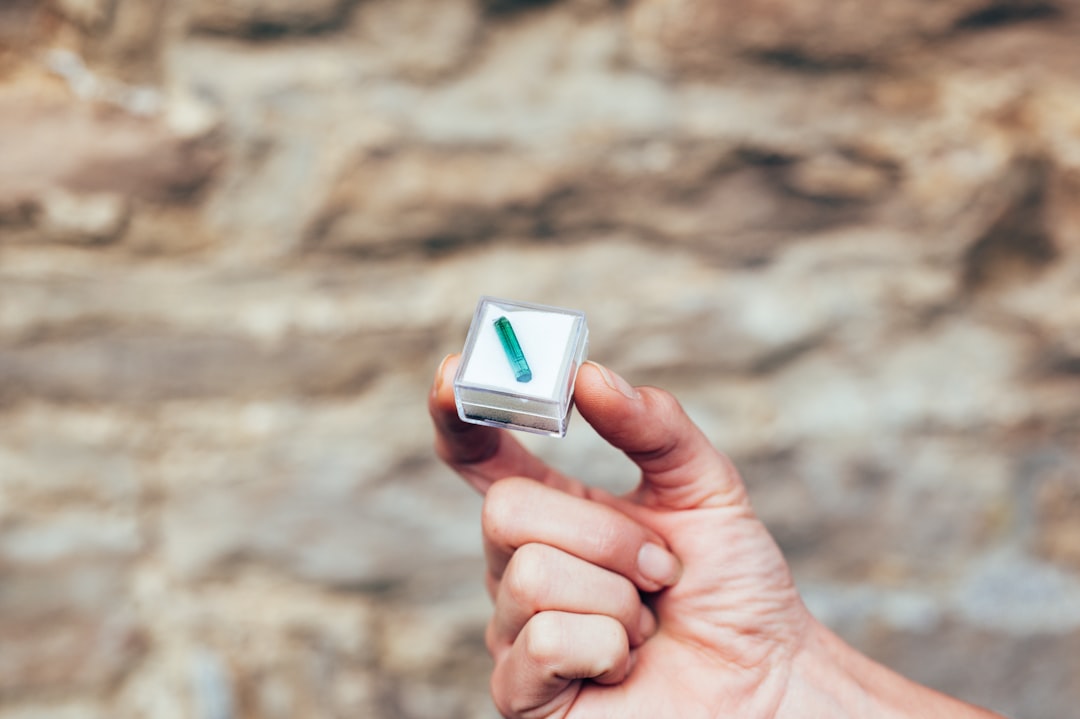 person holding white and green cube