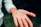 Close-up of hands holding a cluster of clear quartz crystals against a soft, blurred background.