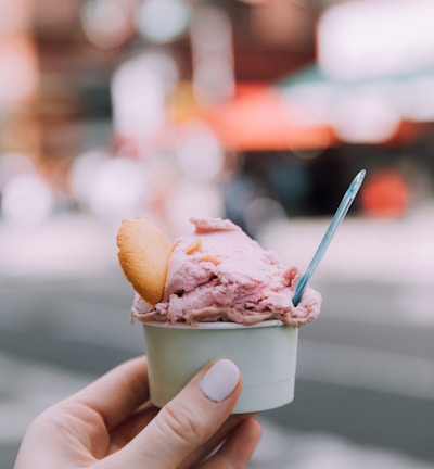 person holding ice cream cone with ice cream