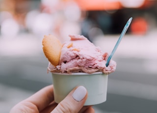 person holding ice cream cone with ice cream