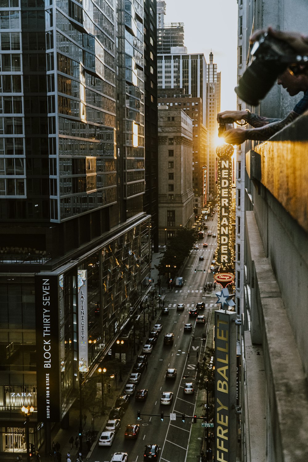 cars on road between high rise buildings during night time