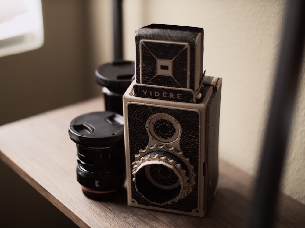 black and silver camera on brown wooden table