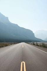A freshly paved highway stretching under a clear blue sky.