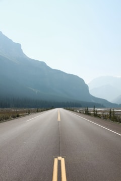 A freshly paved highway stretching under a clear blue sky.